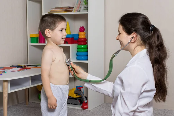 De kinderarts zal auscultiseren de longen en het hart van een kleine jongen 3-4 jaar oud. Pediatrie, huisartsenafspraak. — Stockfoto
