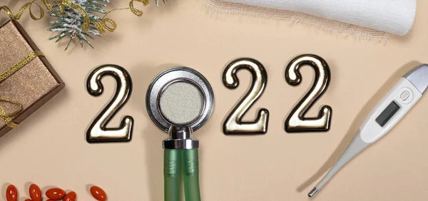Medicina de Año Nuevo 2022. Banner largo sobre temas médicos: fonendoscopio, termómetro sobre fondo beige. — Foto de Stock