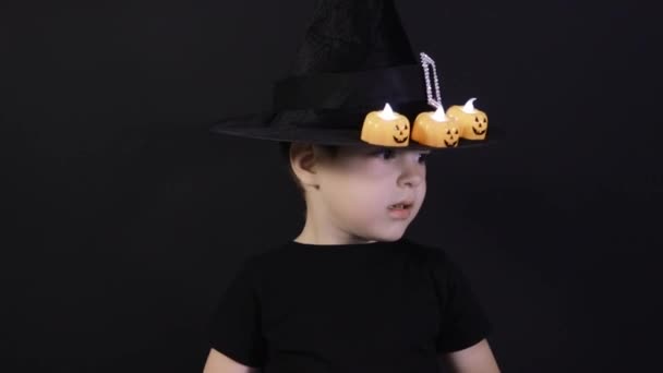 Een kleine jongen van 4 jaar in een tovenaarskostuum bereidt zich voor op Halloween. Vakantie op de kleuterschool. — Stockvideo