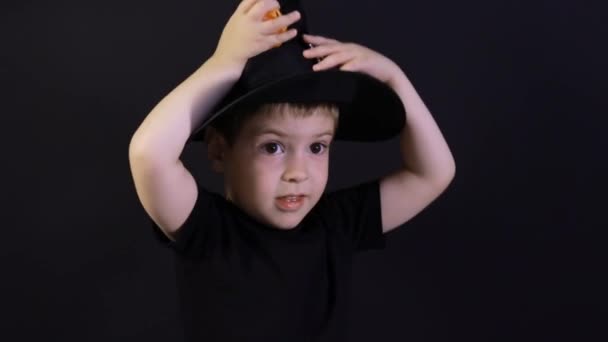 Een kleine jongen van 4 jaar in een tovenaarskostuum bereidt zich voor op Halloween. Vakantie op de kleuterschool. — Stockvideo