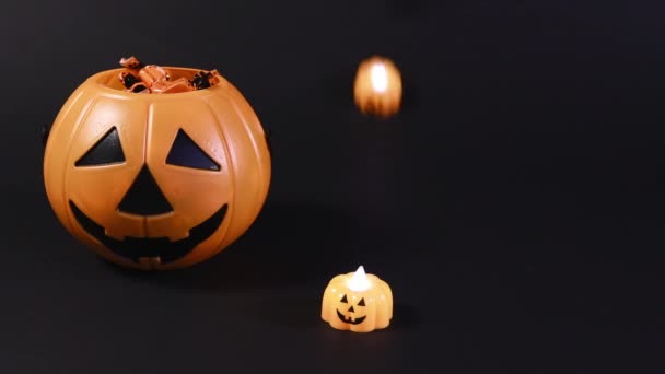 Preparing for Halloween. Pumpkins and candy on a black background, pumpkins roll to the foreground. — Stock Video