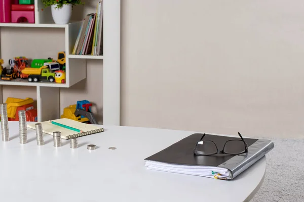 Coins and a folder with documents for a financial literacy course for children with toys with a place for text. — Stock Photo, Image