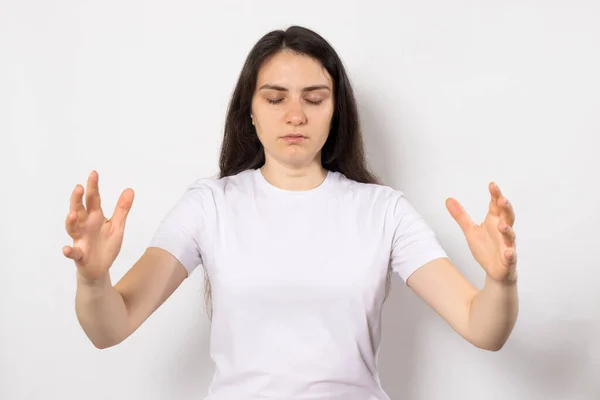 Concentrated woman with closed eyes holds her hands wide, meditates. — Stock Photo, Image