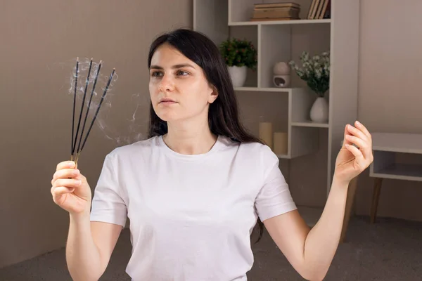 Una mujer sostiene un conjunto de palos aromáticos en sus manos. Aromaterapia, medicina alternativa, tratamiento de neurosis y cefalea. — Foto de Stock