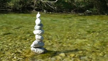 Nehir kenarındaki Taş Cairn Piramidi Yavaş Hareket, Denge Sembolü.