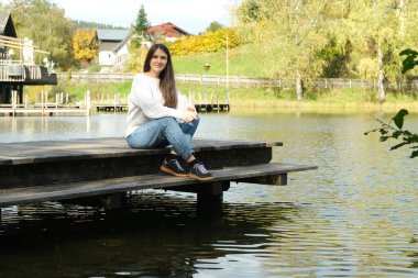 Sonbaharda Gölü kıyısında oturan Esmer Kadın..