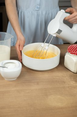 Kadın yumurta çırpıyor şeker karıştırıcı ile, mesaj için boşluk.