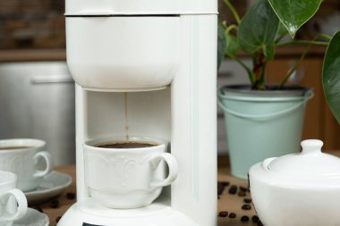 Kahve makinesinde demleme işlemi, sıcak kahve bardağa doldurulur.