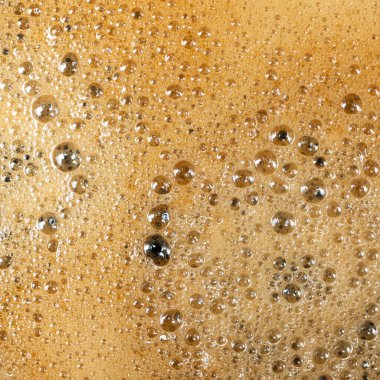 Bol köpüklü altın kahve köpüğünün makro dokusu.