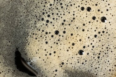 Bol köpüklü altın kahve köpüğünün makro dokusu.