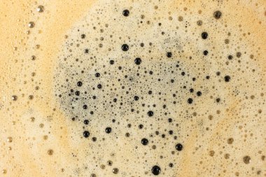 Bol köpüklü altın kahve köpüğünün makro dokusu.