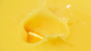 Yavaş çekim portakal dilimlerinin makrosu portakal suyuna dökülüyor.