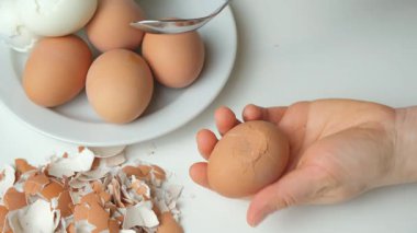 Ellerinizi kapatın, kaynamış yumurta kabuğunu metal kaşıkla kırın.