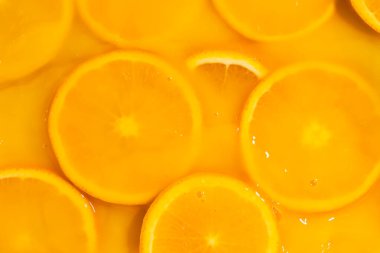 Taze portakal suyunda yüzen portakal dilimleri, yatay makro