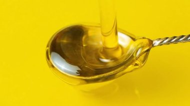 Ekstra saf zeytinyağını gümüş kaşığa yavaş çekimde dök..