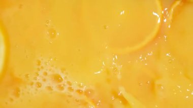 Portakal suyu havuzuna düşen portakal dilimleri güzel dalgalanmalar yaratır.