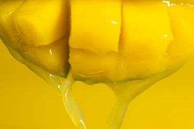 Dilimlenmiş meyve küplerinden akan makro mango suyu..