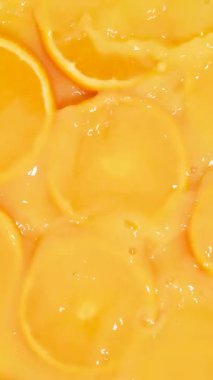 Portakal suyuna dökülen taze portakal dilimlerinin dikey yavaş hareketi