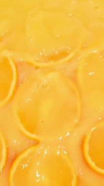 Portakal suyuna dökülen taze portakal dilimlerinin dikey yavaş hareketi