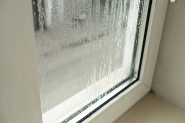 Su çizgileri ve damlacıkları olan sisli camları kapat.