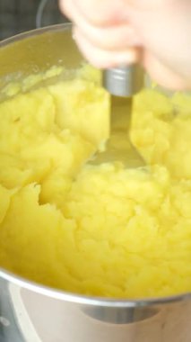 Kaynamış patatesleri metal bir tencerede yakın mesafeden ezmek..