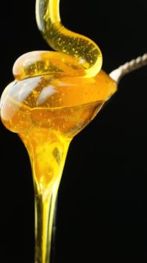 Sinematik yemek makrosu, sıvı bal hareketi ve siyahın dokusu