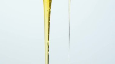 Beyaz zemin üzerinde sıvı doğal bal akışının makro yavaş çekimi.