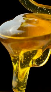 Sinematik yemek makrosu, sıvı bal hareketi ve siyahın dokusu