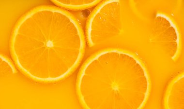 Taze portakal suyunda yüzen portakal dilimleri, yatay makro