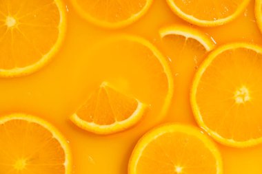 Taze portakal suyunda yüzen portakal dilimleri, yatay makro