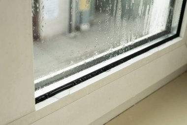 Su çizgileri ve damlacıkları olan sisli camları kapat.