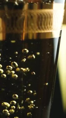 Camda beyaz şarabın makro dikey çekimi, baloncuklar yavaş çekim.