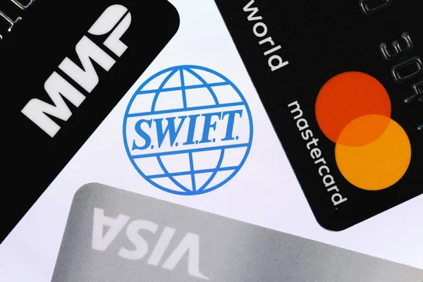 Kazan, Rusya - 4 Mayıs 2021: SWIFT Uluslararası Bankalar Arası Finansal Telekomünikasyon Ağı Toplumu. Üç ödeme sistemi logosuna sahip banka kartları: Visa, Mastercard ve Mir.