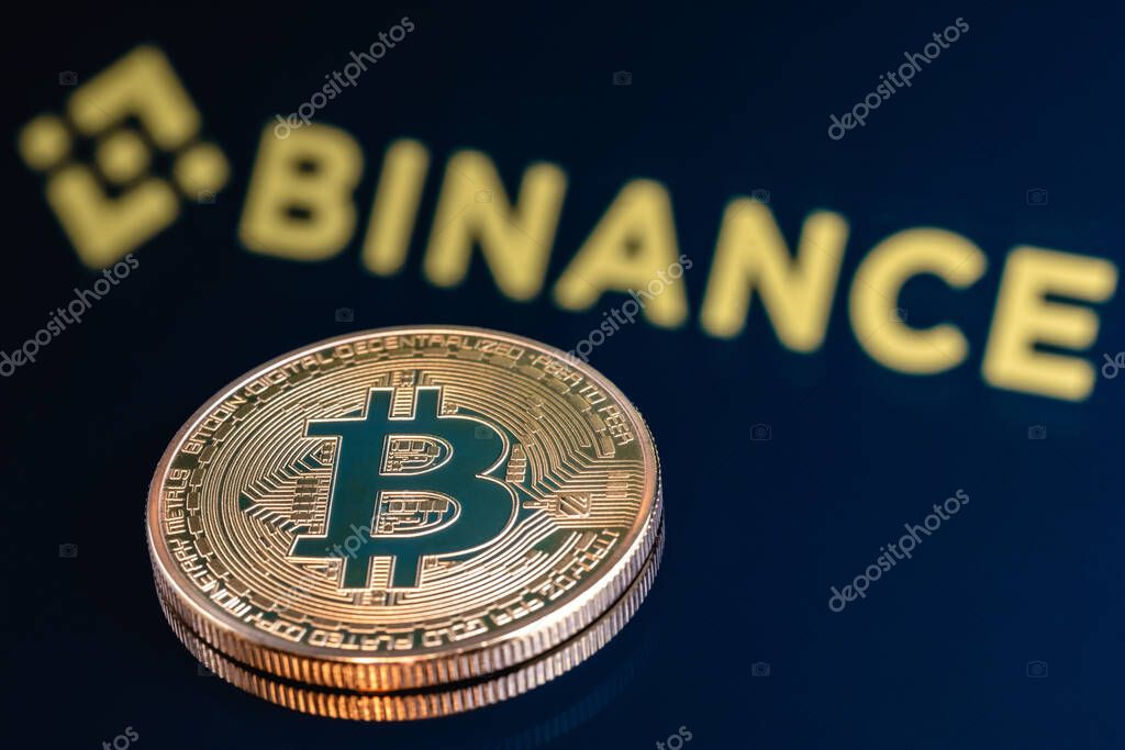 Kazan, Russia - May 17, 2021: Binance is a cryptocurrency exchange that provides a platform for trading various cryptocurrencies. Bitcoin on the background of the BINANCE inscription.