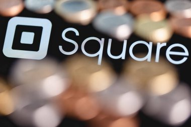 Kazan, Rusya - 30 Mayıs 2021: Square, Inc., elektronik ödemeleri kabul etmek ve işlemek için çözümler üreten bir Amerikan teknoloji şirketidir. Arkaplan kare logosunda bulanık paralar.