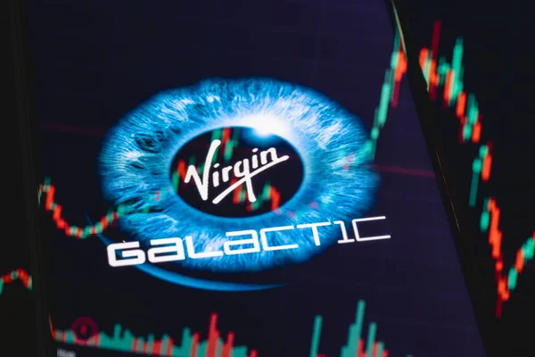 Kazan, Rusya - 31 Mayıs 2021: Virgin Galaktik ticari uzay aracı geliştiren bir şirket. Akıllı telefon ekranında Virgin Galaktik logosu. Yansımada hisse senedi çizelgesi.