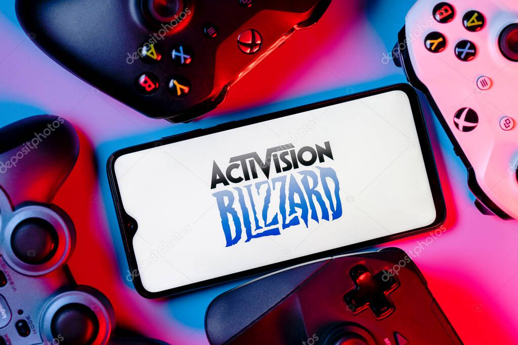 Kazan, Russia - August 7, 2021:  Activision Blizzard, Inc. is an American video game holding company. A smartphone with the Activision Blizzard logo on the screen surrounded by gamepads.