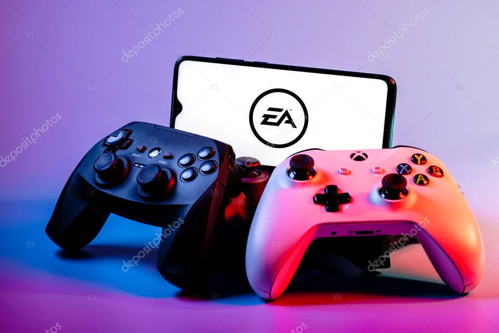 Kazan, Russia - August 14, 2021:  Electronic Arts Inc. is an American video game company. A smartphone with the Electronic Arts logo on the screen on the pile of the gamepads.