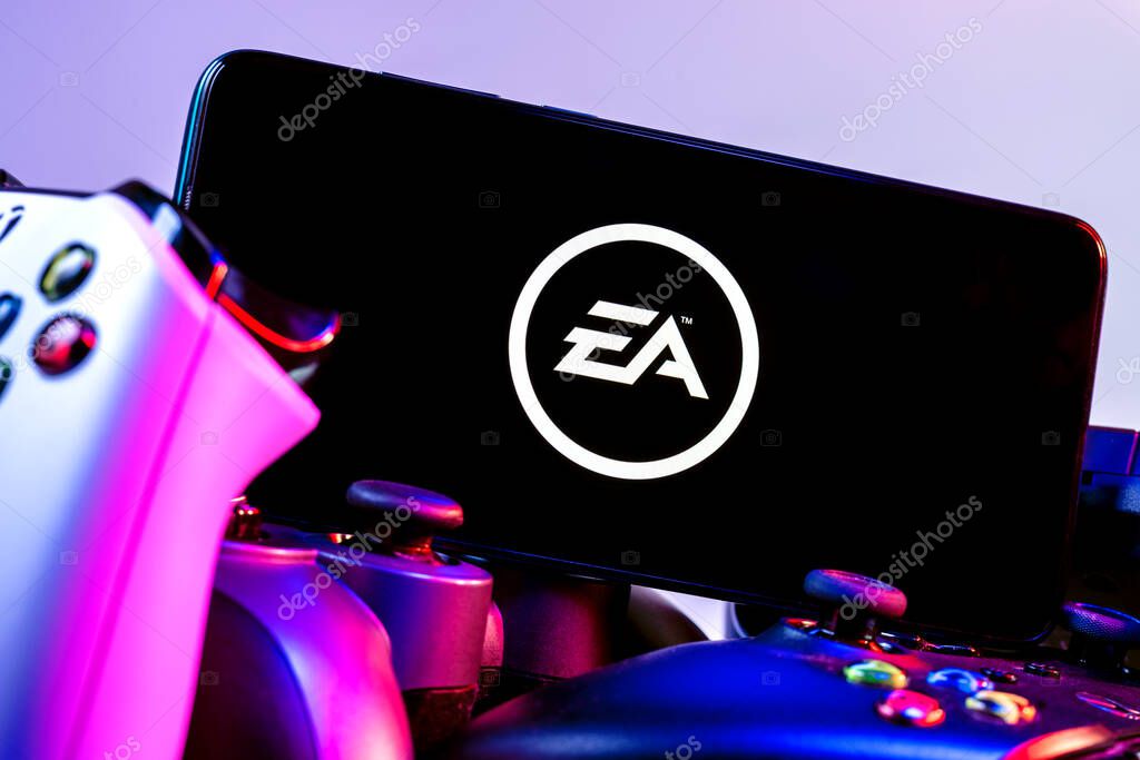 Kazan, Russia - August 14, 2021:  Electronic Arts Inc. is an American video game company. A smartphone with the Electronic Arts logo on the screen on the pile of the gamepads.