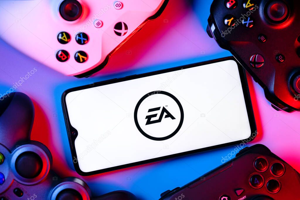 Kazan, Russia - August 14, 2021:  Electronic Arts Inc. is an American video game company. A smartphone with the Electronic Arts logo on the screen surrounded by gamepads.