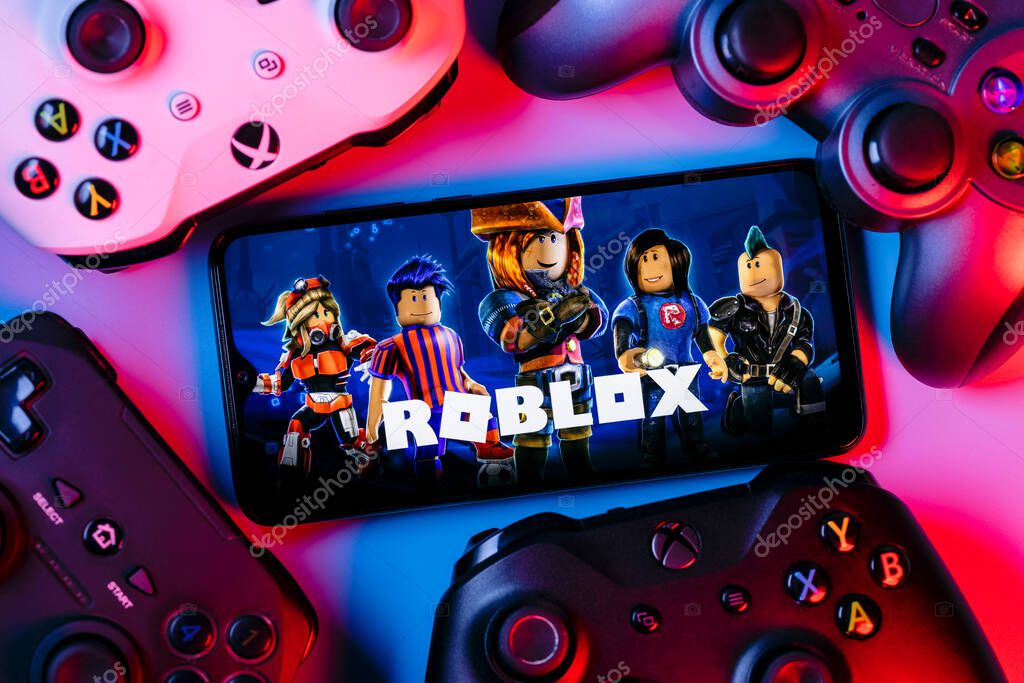 Kazan, Russia - August 25, 2021: Roblox is an online game platform and game creation system. A smartphone with the Roblox logo on the screen surrounded by gamepads.