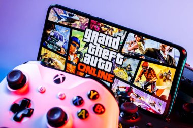 Kazan, Rusya - 17 Eylül 2021: Grand Theft Auto Online, çok oyunculu aksiyon-macera oyunu. Oyun bloknotları yığınının üzerinde GTA Online 'dan bir çerçeve ile akıllı telefon.