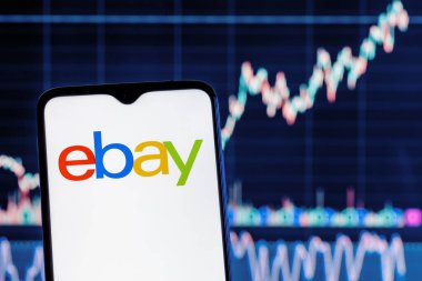 Kazan, Rusya - Sep 25, 2021: eBay online alışveriş, açık artırma ve pazar hizmetleri sunan bir e-ticaret şirketidir. Hisse tablosunun arka planında eBay logosu olan akıllı telefon.