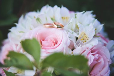 gelin buketi arka plan üzerinde iki altın alyans