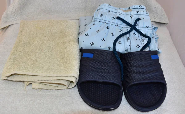 Un par de sandalias, un traje de baño para hombre y una toalla — Foto de Stock