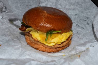 Kahvaltıda sebze ve peynirli yumurta burger yemek.