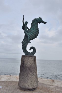 Puerto Vallarta, Mexico - July 17 2024: Puerto Vallarta, Mexico - Famous seahorse statue overlooking the ocean on the Pier, Jalisco, under a cloudy sky