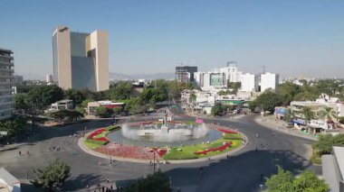 Guadalajara, Meksika 'da şehir silueti ve trafiği olan La Minerva anıtına doğru uçan hava görüntüleri