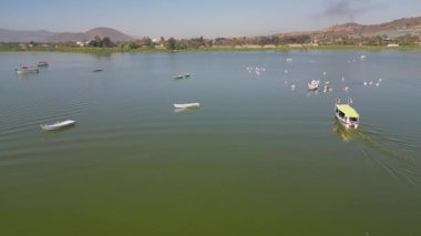 Cajititlan lagününün yüzeyindeki hava kaplaması tekneleri, yeşil kıyı şeridini ve sakin suyu gösteriyor.