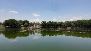 El Dean parkının gölü üzerinde su yansımalarını, ağaçları ve gökyüzünü gösteren pürüzsüz hava görüntüleri